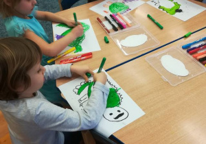 Dzieci przy stolikach rysują smoka wawelskiego.
